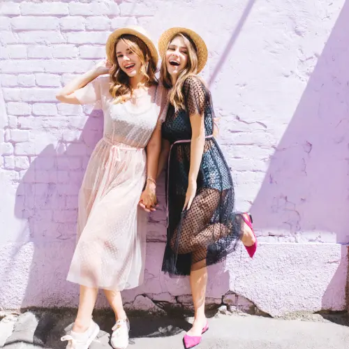 excited-girl-purple-shoes-standing-one-leg-beside-friend-romantic-long-dress